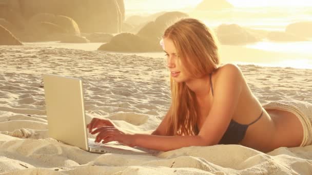 Mujer sonriendo mientras navega por la red en la playa — Vídeos de Stock