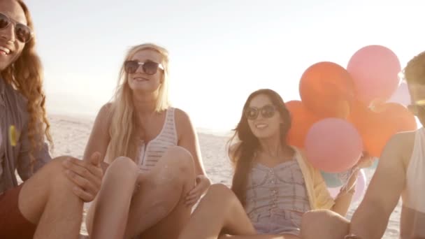 Vrienden spelen met ballonnen op strand — Stockvideo