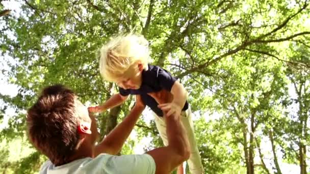 Papà sta gettando il figlio nel parco — Video Stock