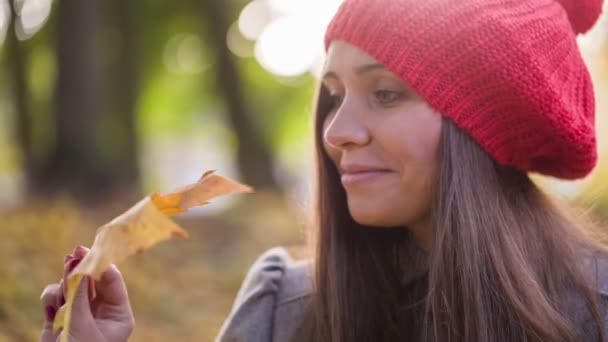 Fille en automne jouer avec la feuille dans le parc 