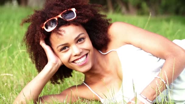 Mujer afroamericana acostada sobre hierba verde — Vídeo de stock