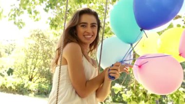 balonları tutarken gülümseyen kadın