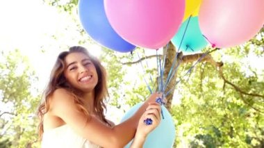 balonları tutarken gülümseyen kadın