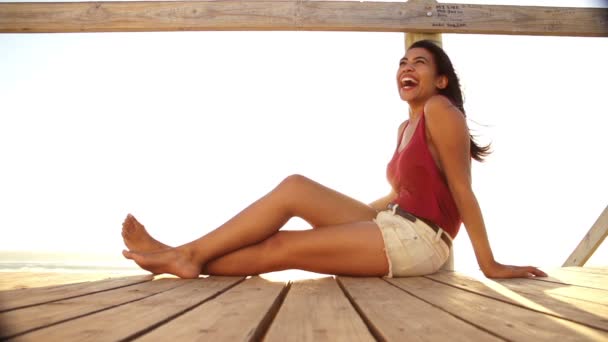 Woman sitting on beach boardwalk — Stock Video