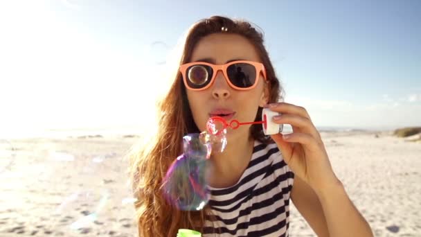 Menina soprando bolhas na praia — Vídeo de Stock