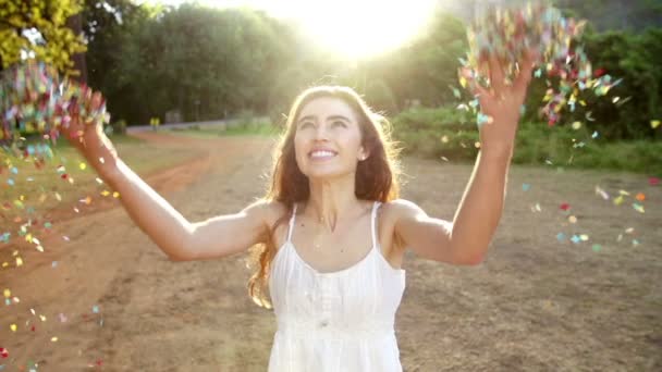 Woman throwing confetti in the park — Stock Video