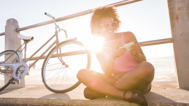 Дівчина з мобільним телефоном біля пляжу — стокове відео