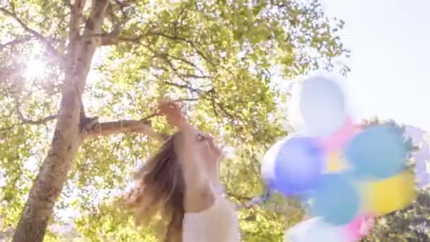 Mujer sonriendo mientras sostiene globos — Vídeos de Stock