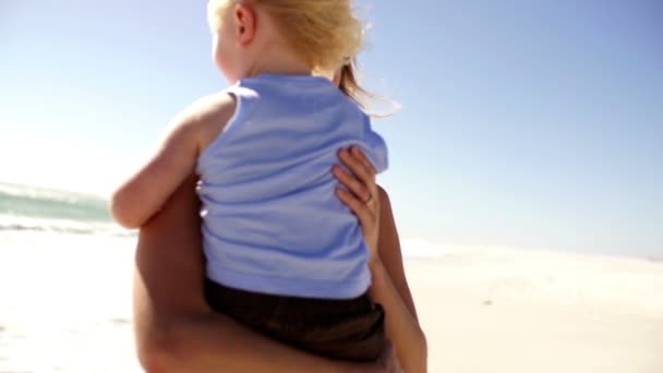 Mutter hebt Sohn am Strand hoch — Stockvideo