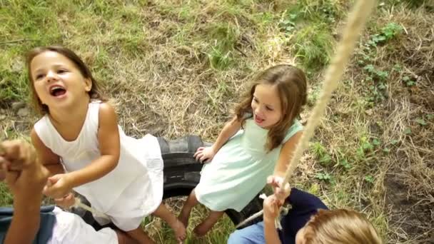 Gruppo di bambini che oscillano su un pneumatico — Video Stock