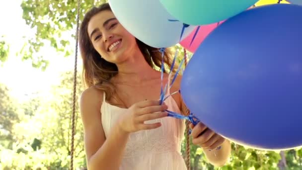 Mujer sonriendo mientras sostiene globos — Vídeos de Stock