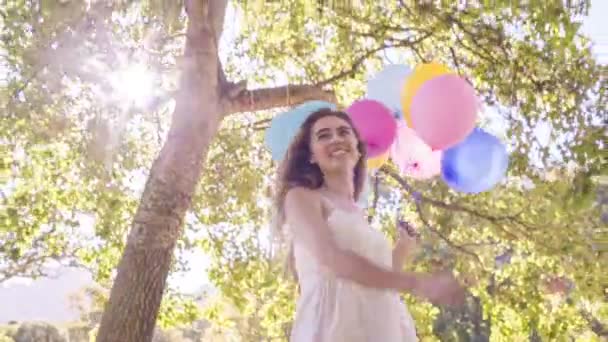Kobieta uśmiechając się trzymając balony — Wideo stockowe