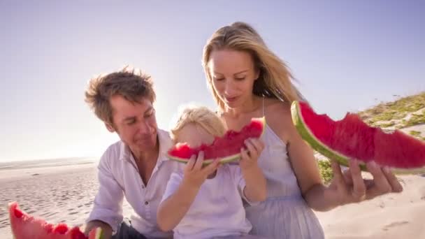 Familia en la playa comiendo sandía — Vídeo de stock