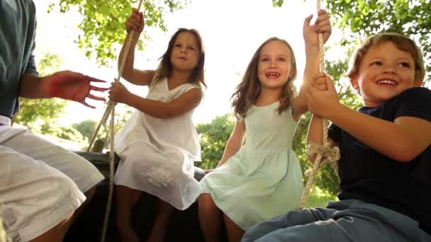 Groupe d'enfants se balançant sur le pneu — Video