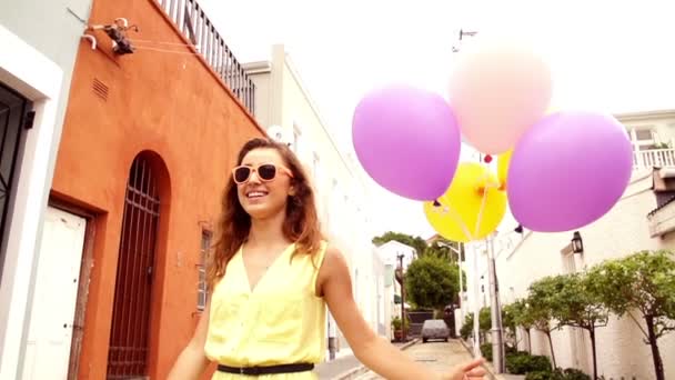 Mujer caminando con globos de helio — Vídeo de stock