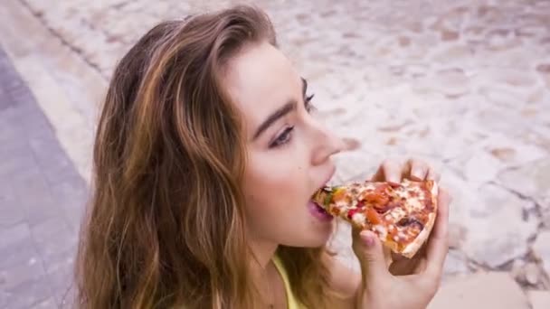 Mujer mordiendo en rebanada de pizza — Vídeos de Stock