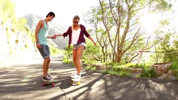 Пара держащихся за руки на скейтборде — стоковое видео