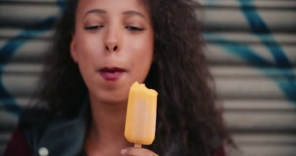 Teen Girl Standing Some Graffitti Holding Orange Colored Ice Lolly — Stock Video