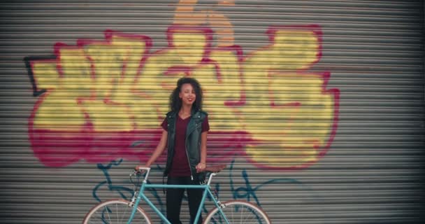 Adolescente Afroamericana Pie Con Bicicleta Engranajes Fijos Frente Coloridos Graffitti — Vídeo de stock