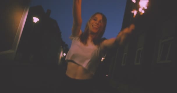 青少年的摇滚女孩 拿着烟花深夜在城市街道上在慢动作跳障碍的时候 — 图库视频影像