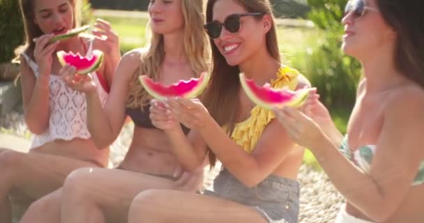 Neljä Teinityttöä Aurinkolaseissa Istuu Ulkona Kesäpäivänä Auringossa Syömässä Tuoreita Vesimeloniviipaleita kuvapankin filmiä