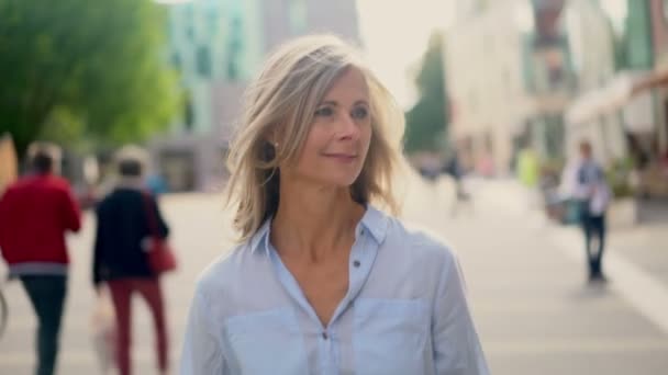 Hymyilevä Kypsä Nainen Harmaine Hiuksineen Kävelee Luottavaisesti Kaupungin Kadulla — kuvapankkivideo