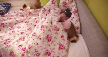 Güneşli bir yatak odasında uyuyan sevimli maskeleriyle iki ergen kızların pijama partisi ve yorgan altında gizleme kapağı