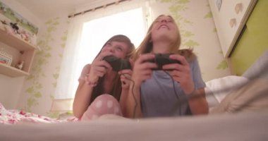 Hala onların elinde düşen ve birlikte onların pijama bir yatakta bir bilgisayar için kontroller ile otururken kahkahalarla gülmekten genç kız oyun