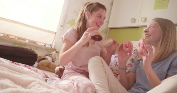 Дві Дівчини Підлітки Піжамах Розважаються Тримаючи Барвисті Пончики Очей Сидячи — стокове відео