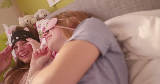 Kaksi Teini Ikäistä Tyttöä Herää Pyjamabileiden Jälkeen Katsoo Toisiaan Nukkuvien — kuvapankkivideo
