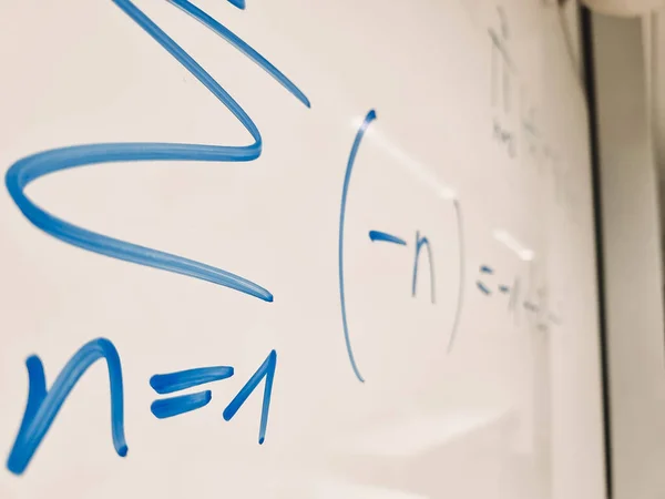 Simboli matematici di un'equazione da una lezione di matematica su una lavagna bianca — Foto Stock