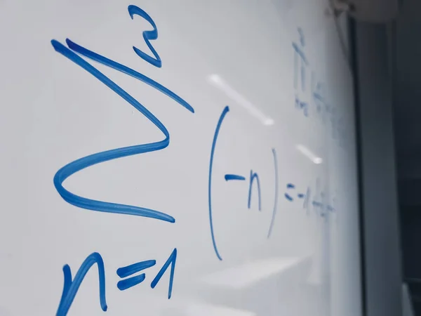 Simboli matematici di un'equazione da una lezione di matematica su una lavagna bianca — Foto Stock