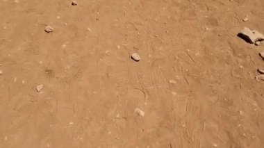 Çölde kırmızı kum ve taşlar olan tozlu bir toprak. Yüksek kaliteli FullHD görüntüler