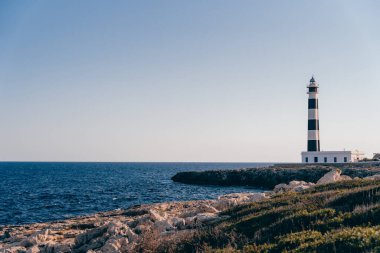 İspanya 'nın Menorca adasındaki güzel mavi deniz feneri. Deniz feneri çok uzaklardan yol gösteriyor.
