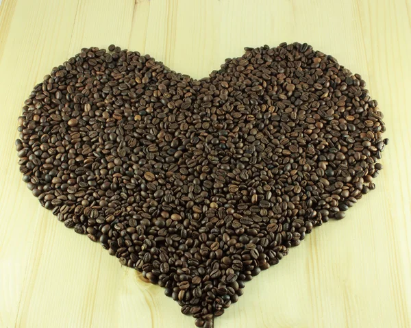 Coeur de grains de café sur un fond en bois — Photo