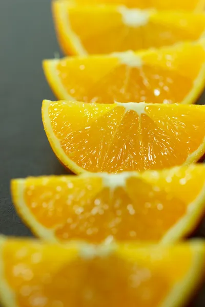 Pedaços de laranja em um fundo de madeira — Fotografia de Stock