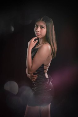 Stüdyoda siyah arka planda izole edilmiş Latin bir kızın yan portresi, alternatif model konsepti..