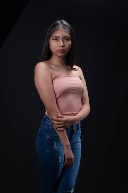 Stüdyodaki İspanyol kızın ön portresi siyah arka planda izole edilmiş, alternatif modelleme konsepti.