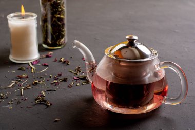 Siyah zemin üzerinde kırmızı böğürtlen çayı hazırlama, çayın iş yoğunluğuna nasıl yardımcı olduğu konsepti