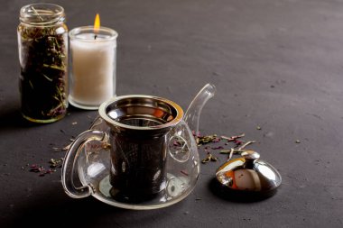 Siyah zemin üzerinde çay olan bir çaydanlığın yan görüntüsü, çay hazırlama kavramı..