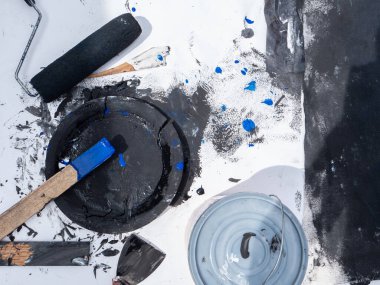 Boyacı aksesuarları, siyah boyalı konteynır, mavi boyalı bir tahta parçası, beyaz arka planda paten ve palet bıçağı.