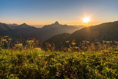 Avusturya, Vorarlberg 'de yürüyüş yaparken dağların tepesinden güzel bir gün batımı yürüyüşü.