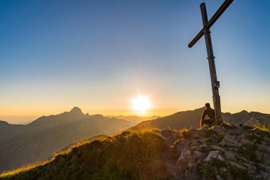 Avusturya, Vorarlberg 'de yürüyüş yaparken dağların tepesinden güzel bir gün batımı yürüyüşü.