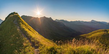 Avusturya, Vorarlberg 'de yürüyüş yaparken dağların tepesinden güzel bir gün batımı yürüyüşü.