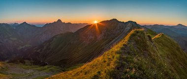 Avusturya, Vorarlberg 'de yürüyüş yaparken dağların tepesinden güzel bir gün batımı yürüyüşü.