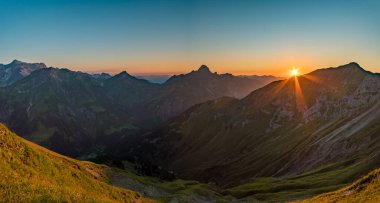 Avusturya, Vorarlberg 'de yürüyüş yaparken dağların tepesinden güzel bir gün batımı yürüyüşü.