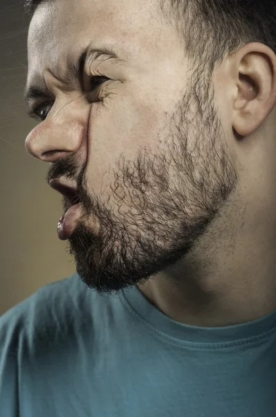 Young man smashing his face against the scratched glass — Stock Photo, Image