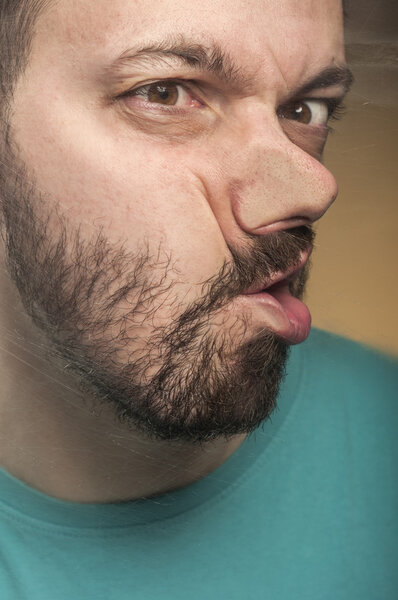 Молодой человек разбивает лицо о стекло.
