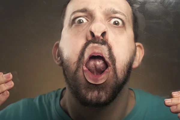 Man blowing to a glass making funny face — Stock Photo, Image