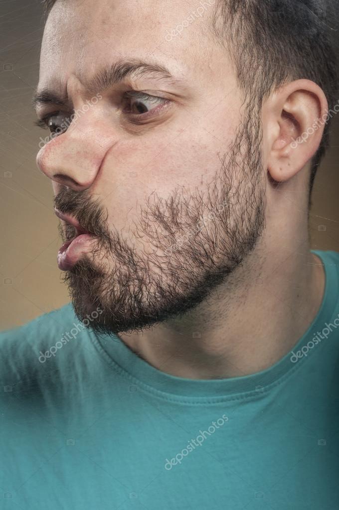 Young man smashing his face against the scratched glass — Stock Photo